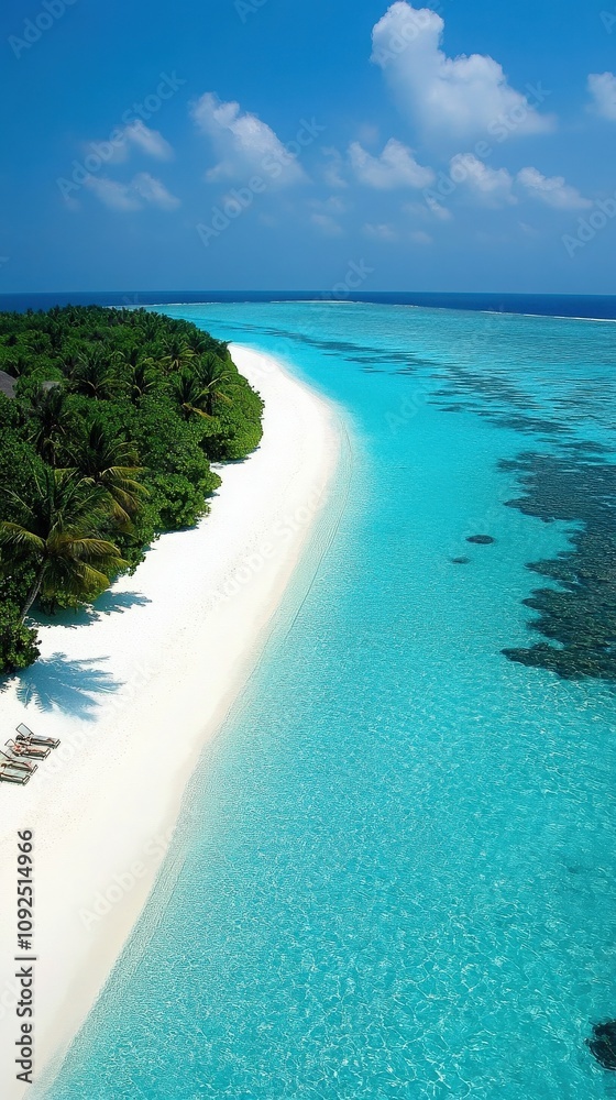 A beautiful tropical beach features soft white sand and crystal-clear turquoise waters, bordered by vibrant green foliage. This idyllic setting offers tranquility and stunning natural beauty.