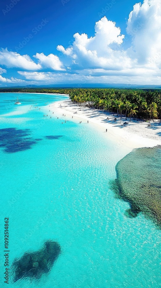 Bright turquoise waters lap at a pristine white sand beach dotted with palm trees. People enjoy the sunny day, creating a vibrant atmosphere in this tropical paradise.