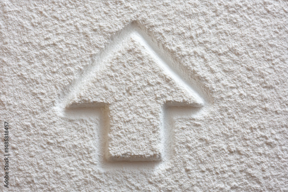 A close-up view of a textured white wall featuring a raised arrow shape. The design appears simple yet effective, implying direction or focus.