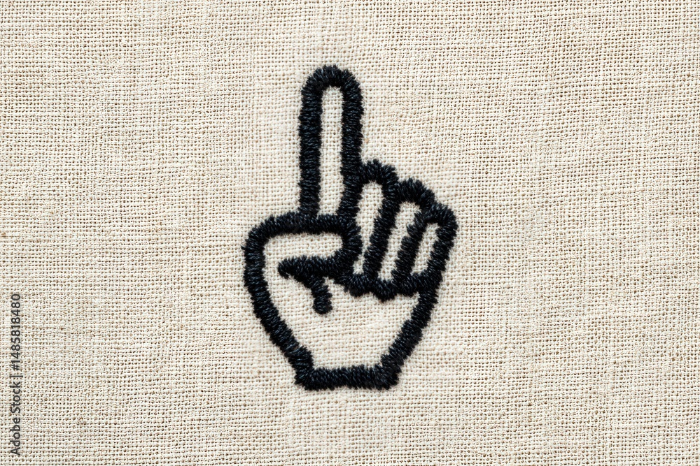 A hand with a raised index finger is embroidered on a beige fabric background. This gesture often signifies asking for attention or pointing out something important.