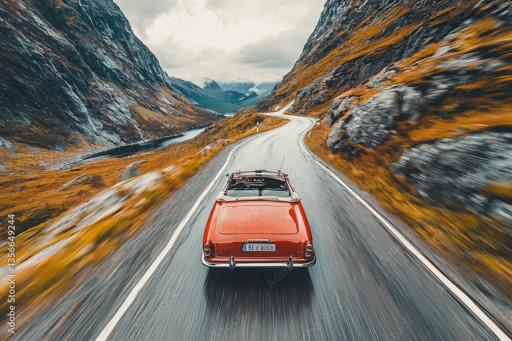 A red vintage convertible cruises down a twisting road surrounded by majestic mountains and lush valleys.