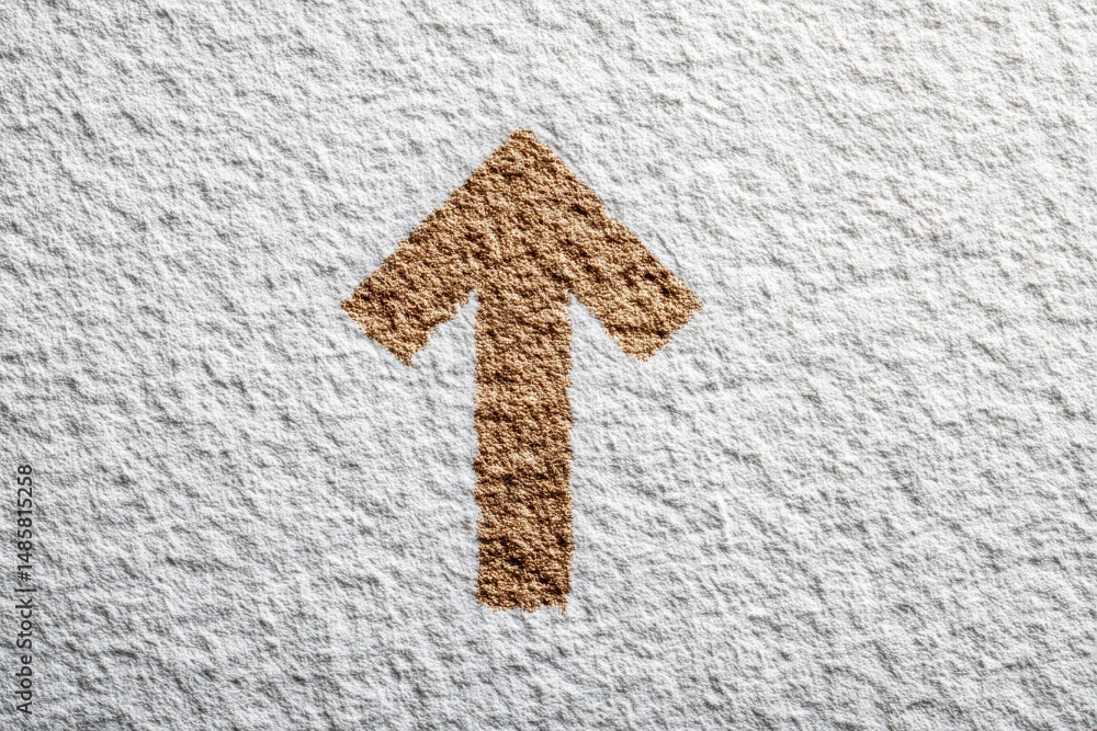 A tan arrow points upward. The arrow and background surface have a rough, textured appearance. The arrows color contrasts with the white, uneven surface.